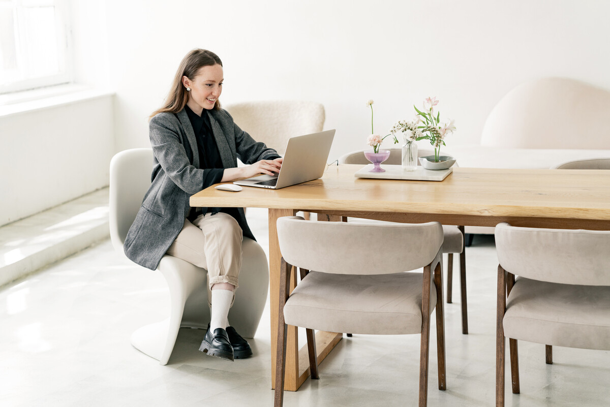 Mujer trabajando en su mesa, con una computadora via online